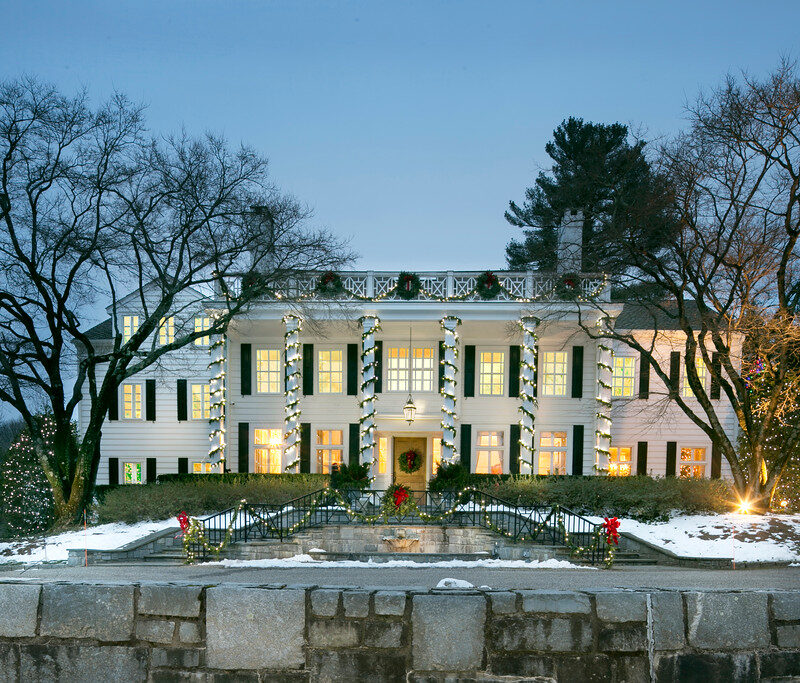 garland and string lights wrapped around railing and pillars, illuminated at dusk